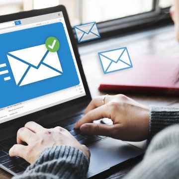 campaigner email marketing program software platform woman sending email on laptop white envelope blue background on laptop monitoir